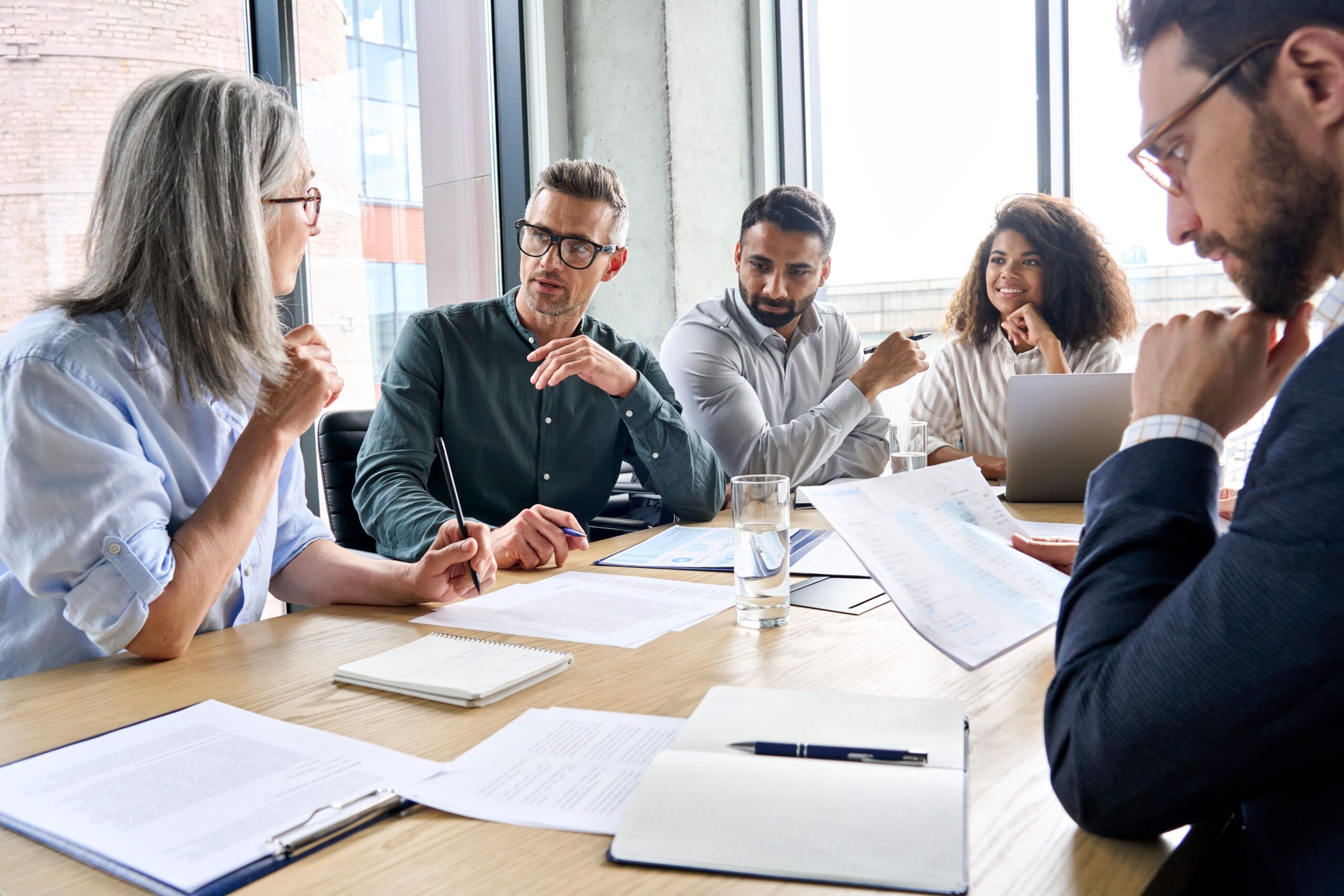 diverse group of professionals engaged in conversation at conference table