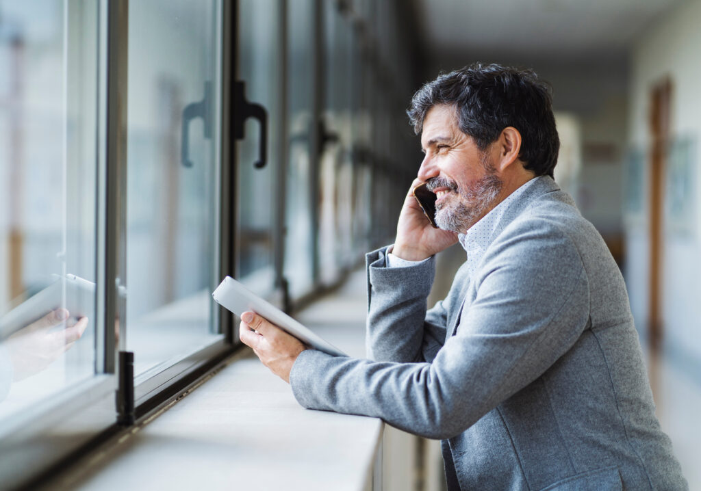 teacher talking on phone in school hallway