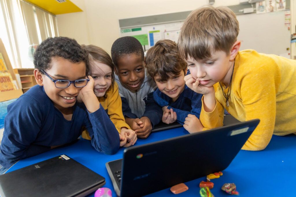 Cambridge School District students|teacher helping student with writing task|Cambridge Public Schools logo