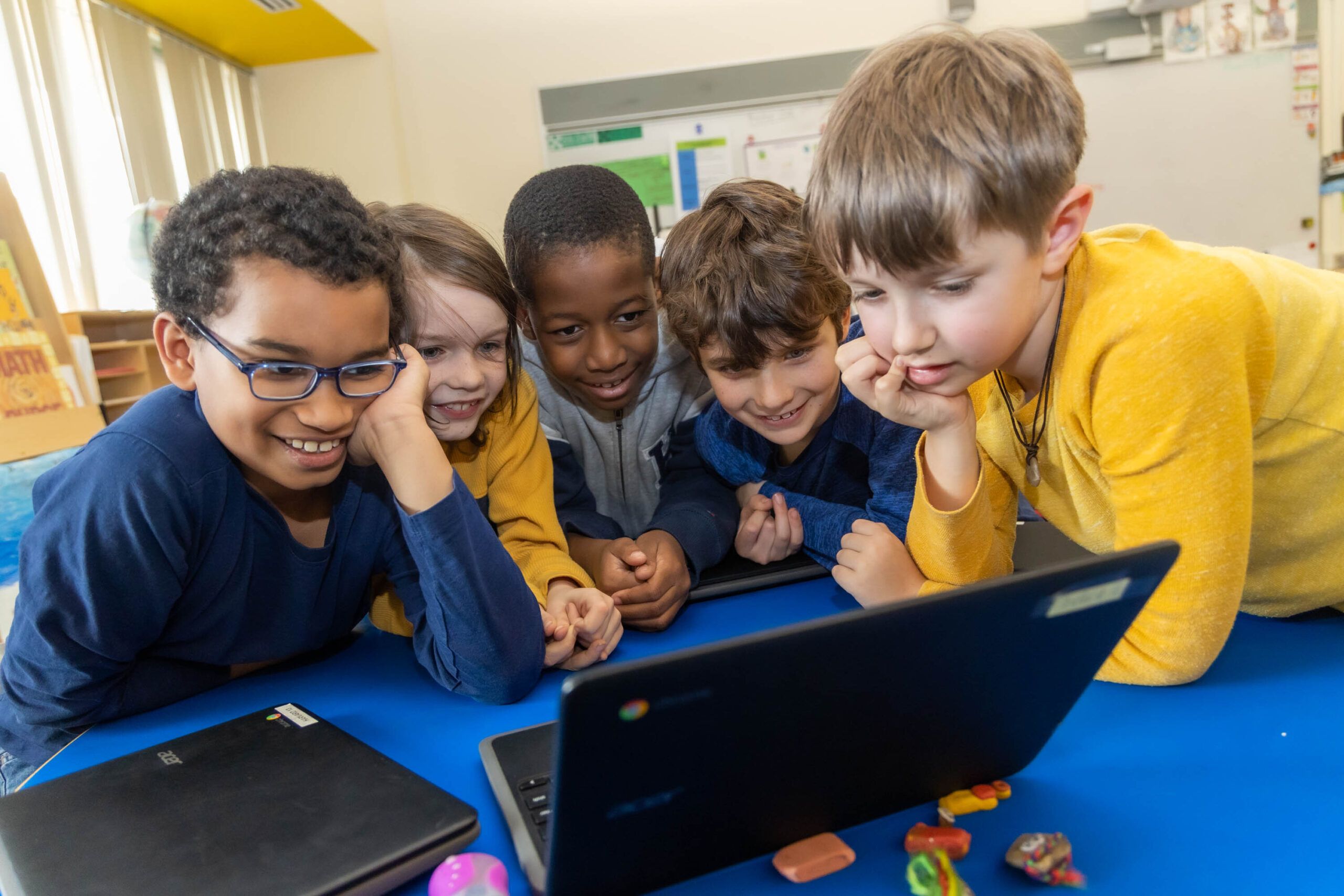 Cambridge School District students|teacher helping student with writing task|Cambridge Public Schools logo