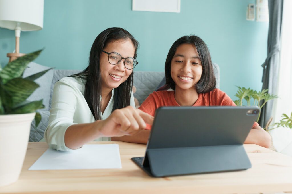mother and daughter looking at tablet