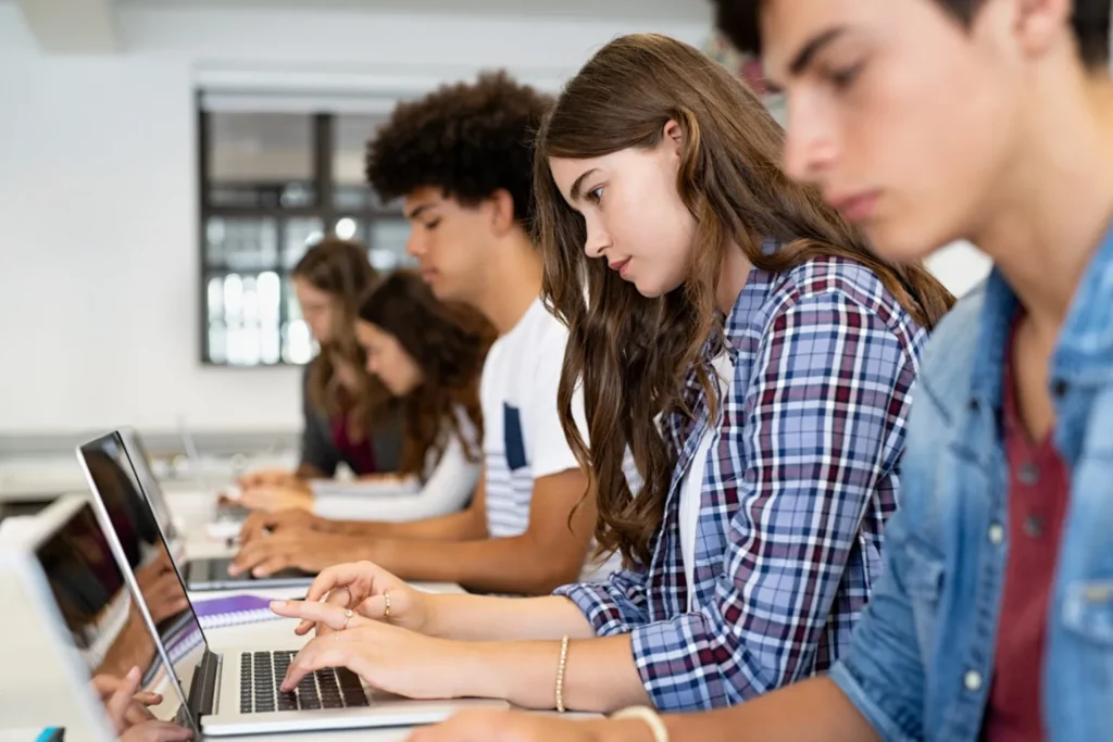 students in classroom using devices