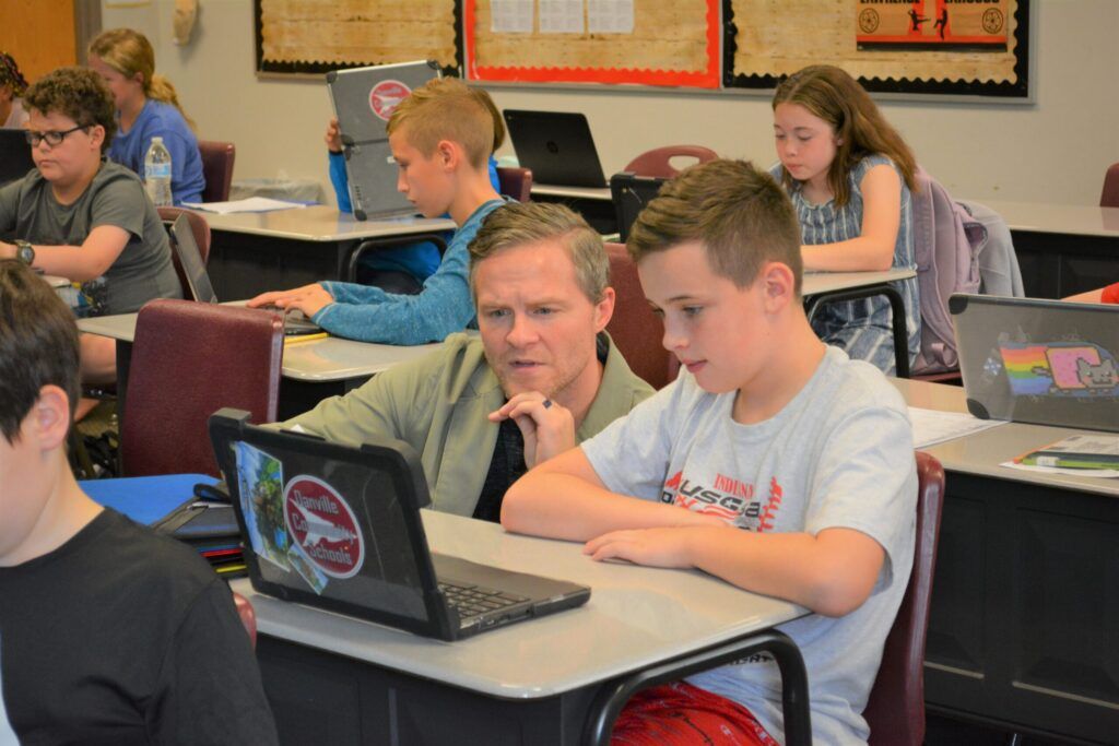 teacher helping student in classroom|Danville Community School Corporation logo|Danville Case Study PDF|Danville Case Study PDF
